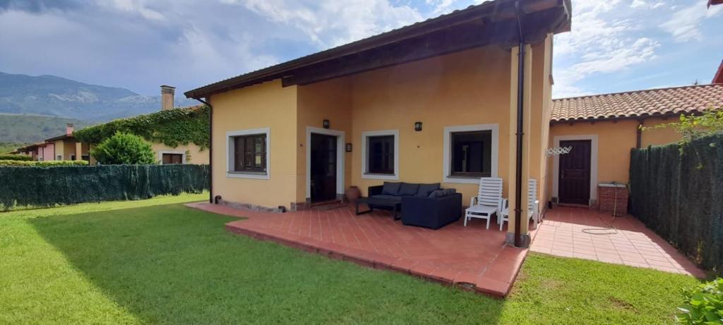 a house with a patio and a couch in a yard at Gestiona2R - Villa con finca, Piscina-Padel-Golf in Llanes