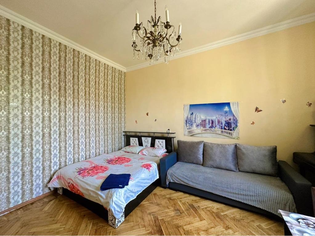 1 dormitorio con 1 cama y 1 sofá en Karson Guest House and Tours, en Ereván