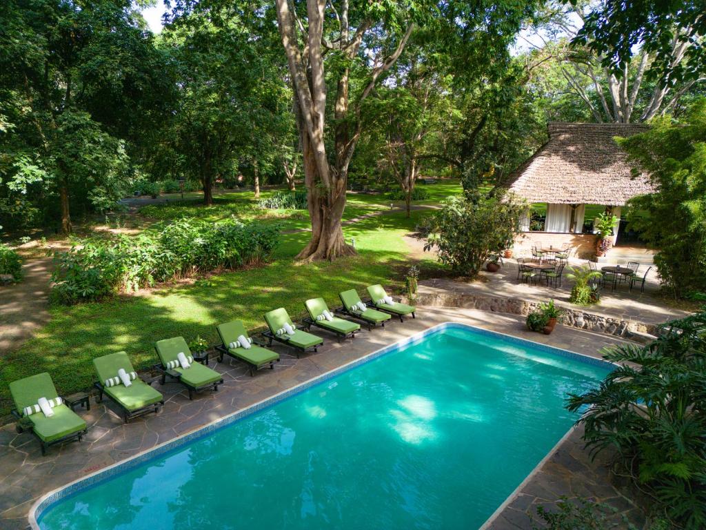 una vista aérea de una piscina con sillas y una casa en Rivertrees Country Inn, en Usa River