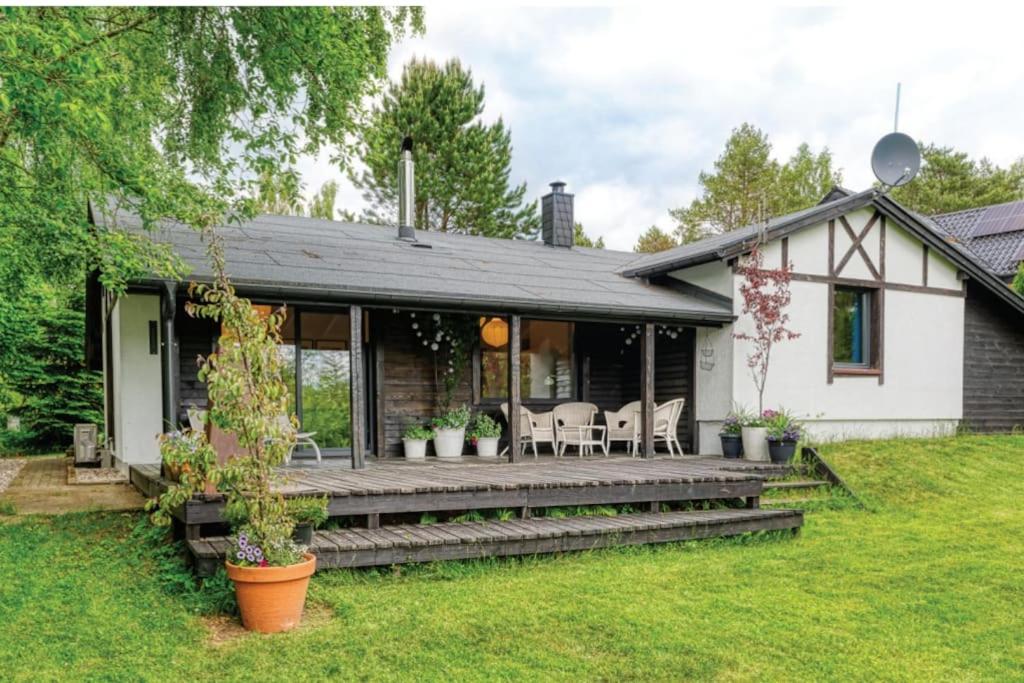 uma casa com um alpendre com cadeiras em Letni dom nad jeziorem Kaszuby Trójmiasto em Bieszkowice