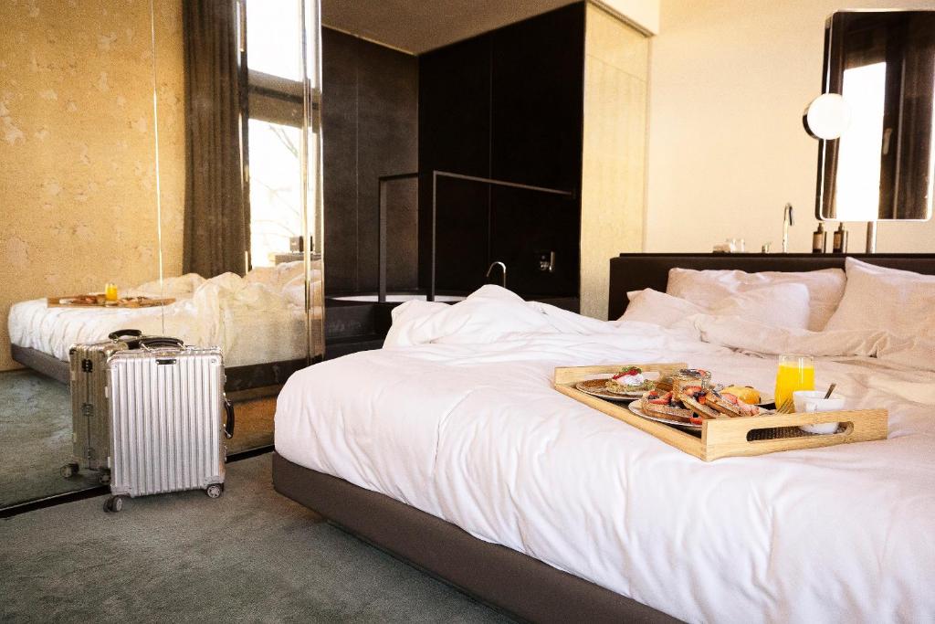 a hotel room with a bed with a tray of food on it at W Amsterdam in Amsterdam