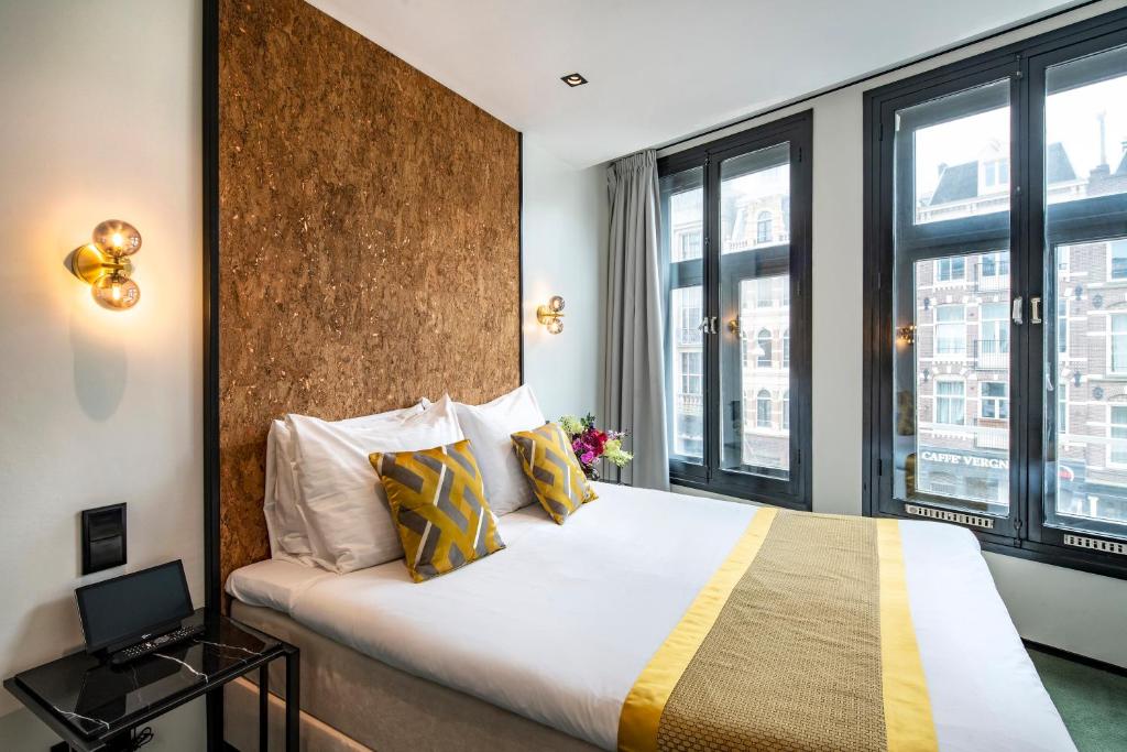 a hotel room with a bed and two windows at Sotel Amsterdam Central Station in Amsterdam