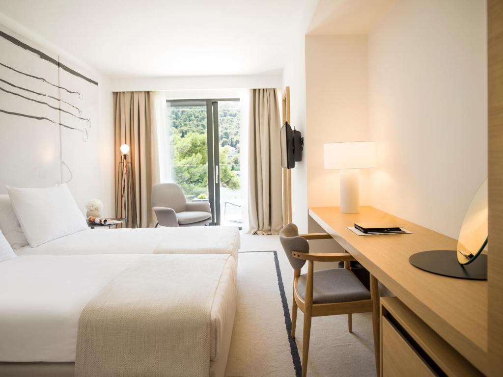 een hotelkamer met een bed en een bureau bij Hotel Kompas in Dubrovnik