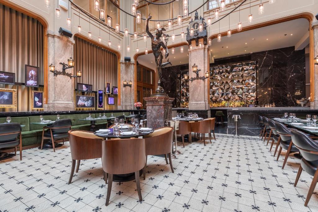 a restaurant with tables and chairs in a room at W Amsterdam in Amsterdam