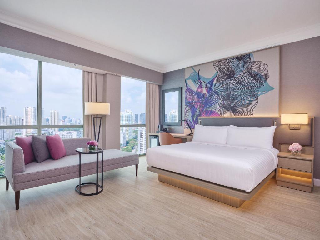 Grand Copthorne Waterfront في سنغافورة: غرفة نوم بسرير واريكة ونوافذ