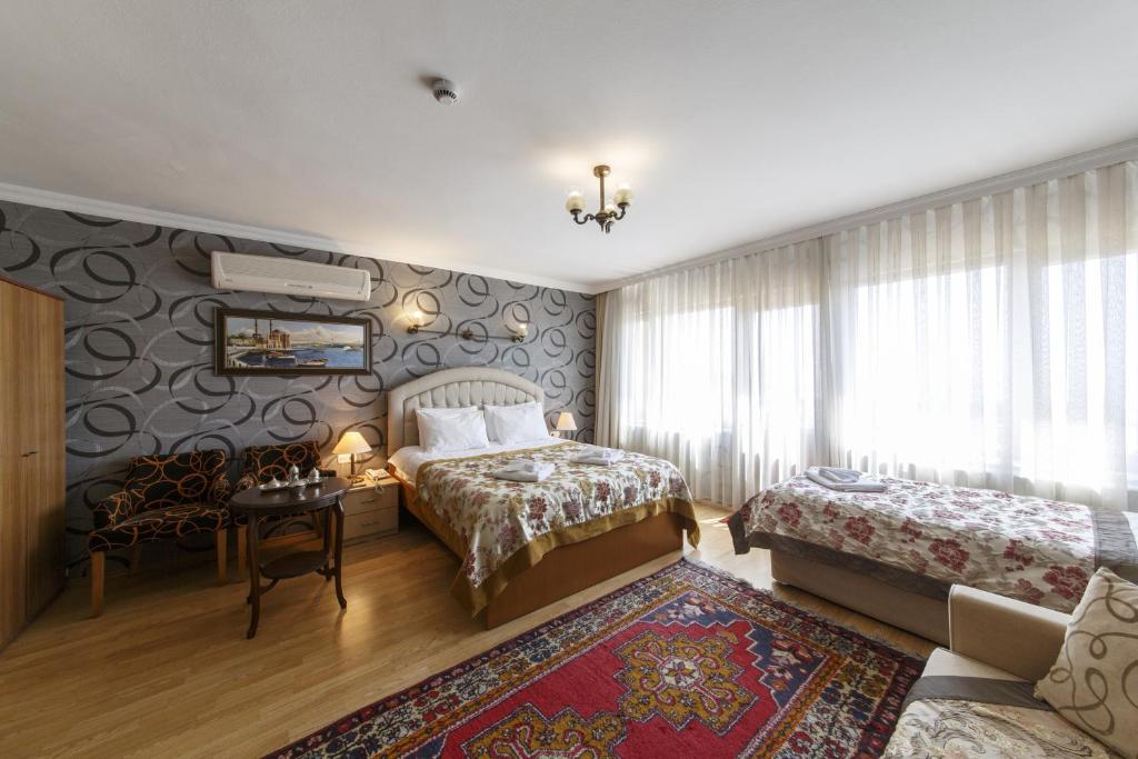 a bedroom with two beds and a table and a couch at Hotel Ipekyolu in Istanbul