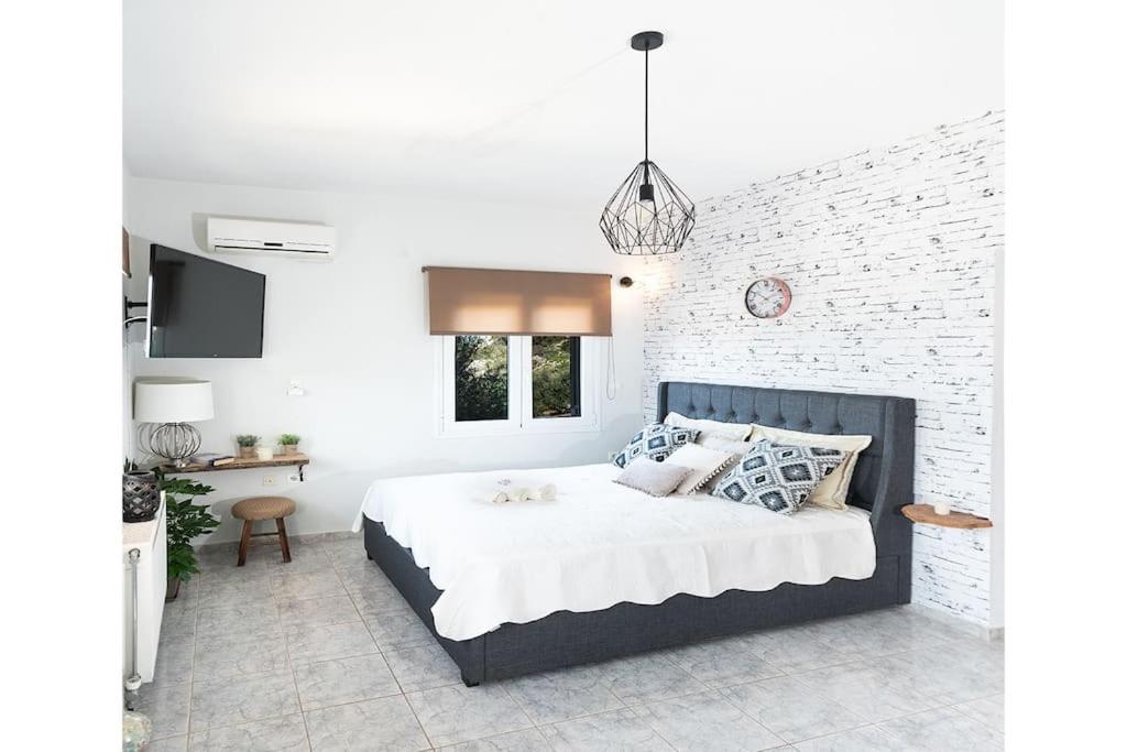 een slaapkamer met een bed en een bakstenen muur bij “Shiny” sea view apartment at Istron in Agios Nikolaos