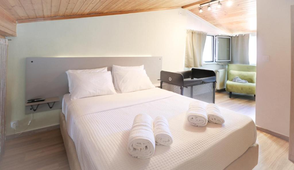 a bedroom with a white bed with towels on it at Family beach house near airport in Artemida