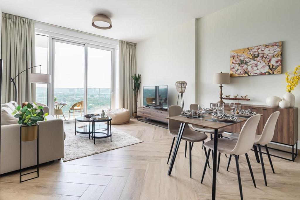 a living room with a table and chairs and a couch at Frank Porter - 1 Residences West in Dubai