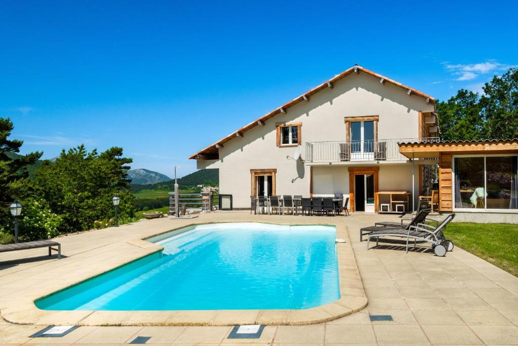 a villa with a swimming pool in front of a house at Domaine De La Plaine in Caille