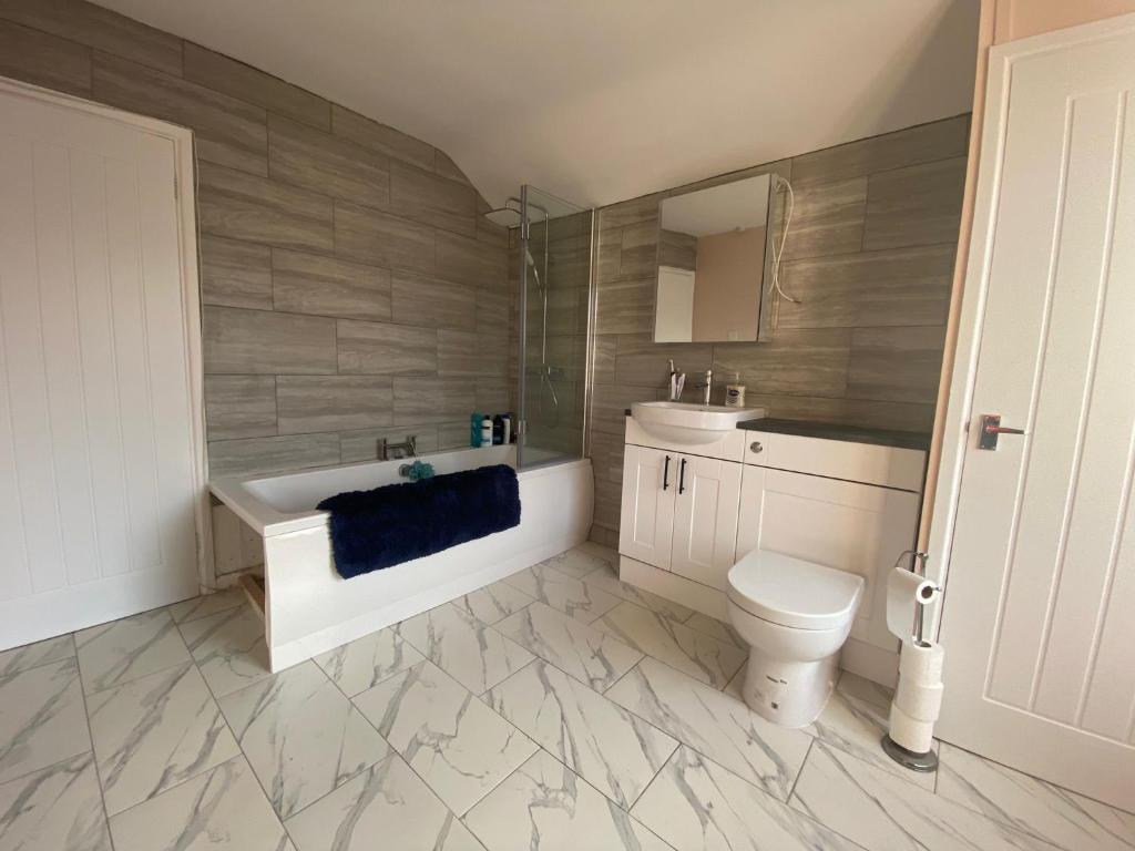 a bathroom with a tub and a toilet and a sink at Private double room in our Cardiff Home in Cardiff