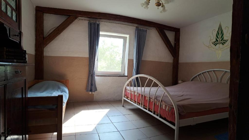 1 Schlafzimmer mit 2 Betten und einem Fenster in der Unterkunft Śródziemie Lorien in Leśno