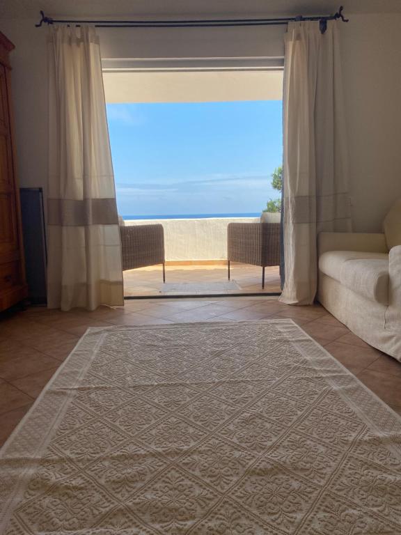 a living room with a large window with a view of the ocean at Villa Belinda in Santa Margherita di Pula