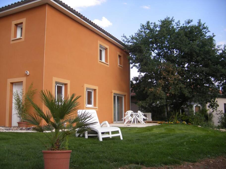 a house with two white chairs in the yard at Maison tout confort Figeac in Figeac
