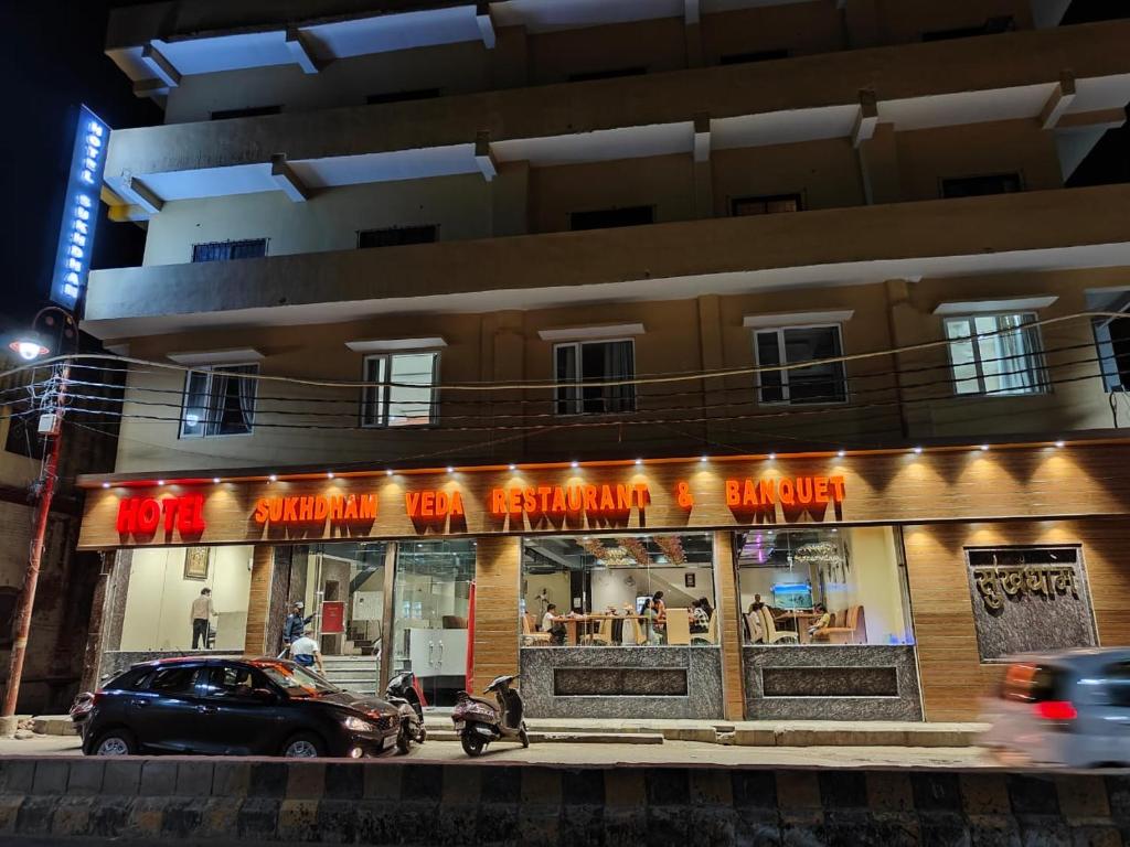 un edificio con un restaurante en una calle por la noche en Hotel Sukhdham, en Allahābād