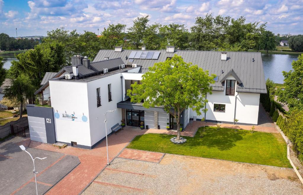 an aerial view of a white house with a tree at Apartamenty nad Zalewem ARKADIA w Suwałkach in Suwałki