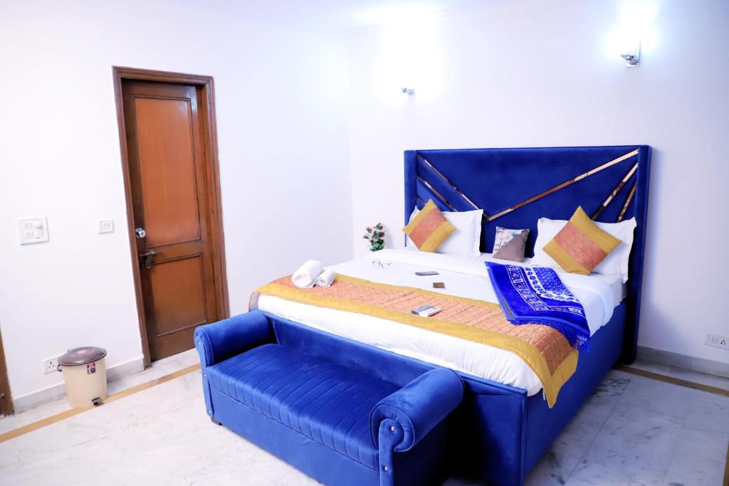 a large bed with a blue headboard in a room at Divine India Service Apartment 1bhk, D-198,UGF in New Delhi