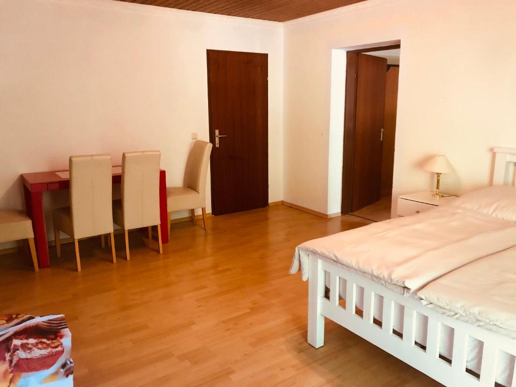 a bedroom with a bed and a table and chairs at Holmes Café & Pension in Engelhartszell