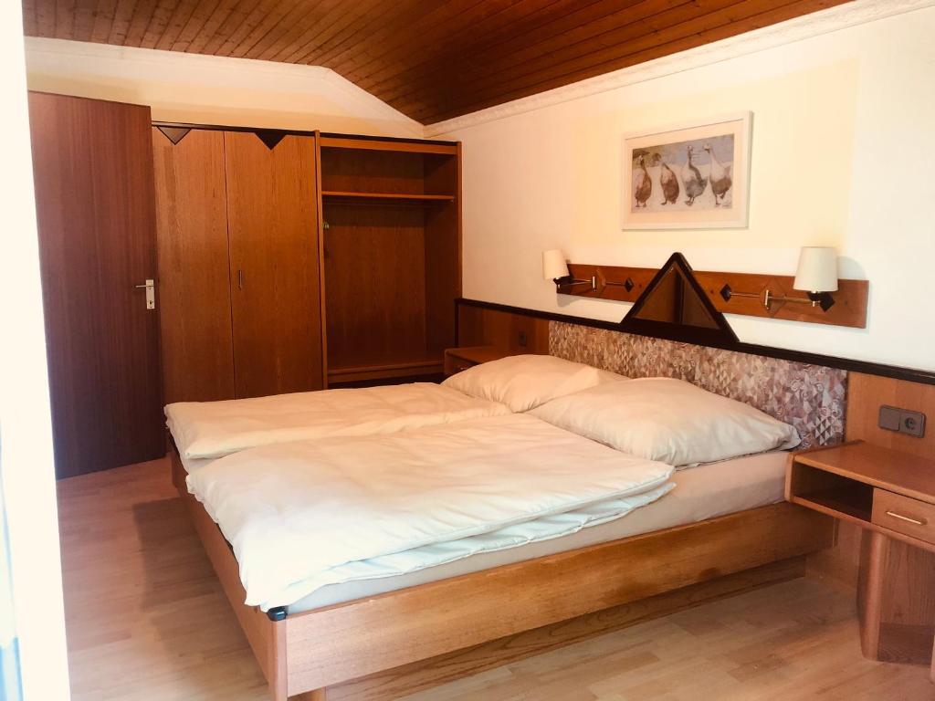 a bedroom with a large bed with a wooden headboard at Holmes Café & Pension in Engelhartszell