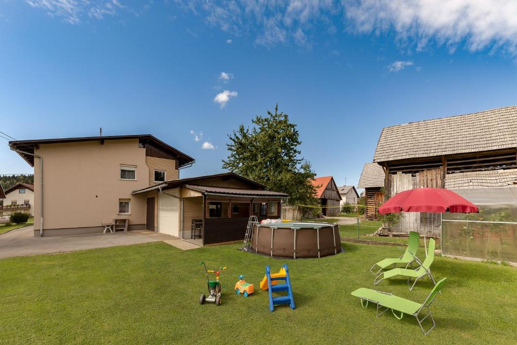 un patio con sillas, una mesa y una sombrilla en Pool House Mržek Family Friendly - Happy Rentals en Nova Vas
