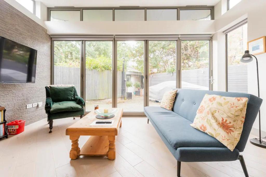 a living room with a blue couch and a table at The Studio House - Crouch End in London