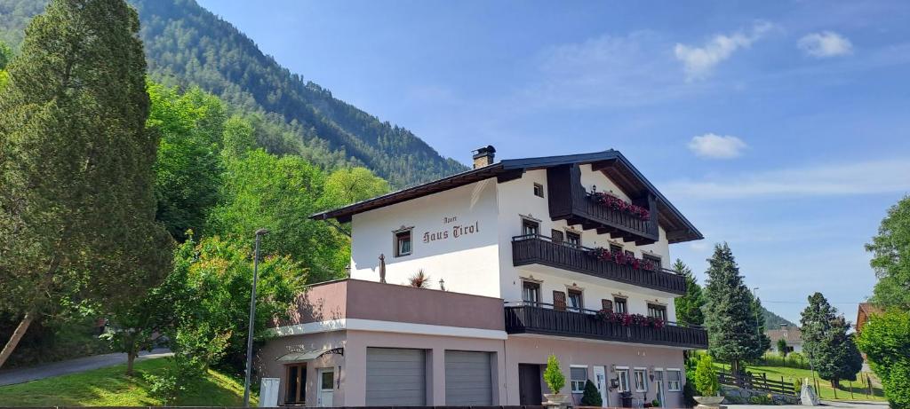 un grand bâtiment blanc avec balcon sur une montagne dans l'établissement Haus Tirol Appartements, à Ried im Oberinntal