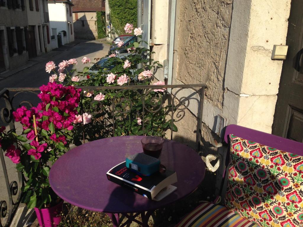une table violette avec un livre à côté des fleurs dans l'établissement Laroumette, à Salies-de-Béarn