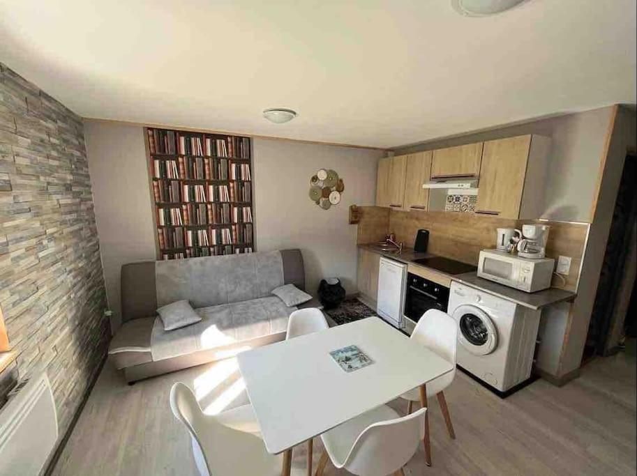 Il comprend un petit salon avec une table et une cuisine. dans l'établissement Le nid douillet, à Le Mont-Dore