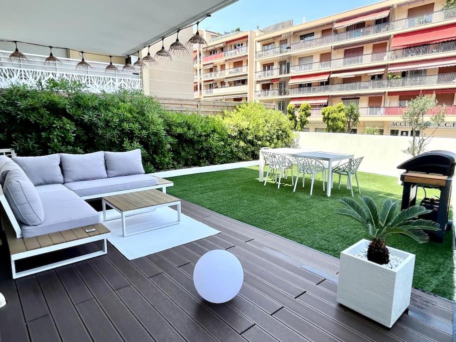 - un patio avec un canapé et une table dans l'établissement Appart Cosy French Riviera - Terrasse + Parking, à Saint-Laurent-du-Var