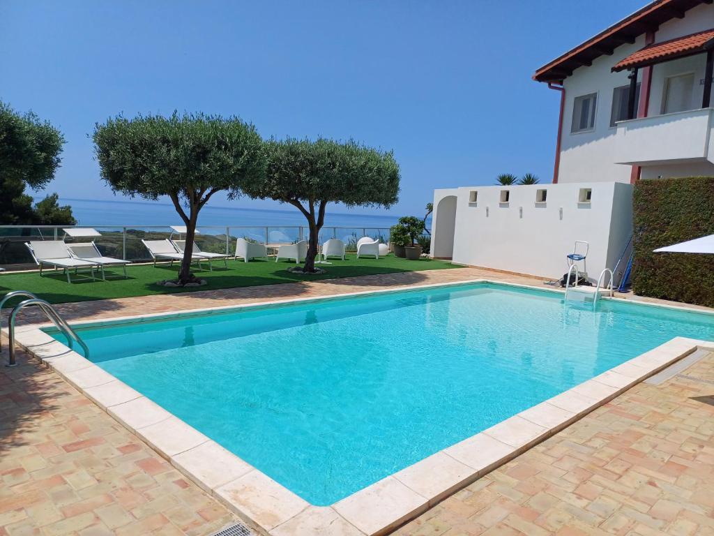 a swimming pool in a villa with the ocean in the background at Oasi del Borgo in Borgo Bonsignore