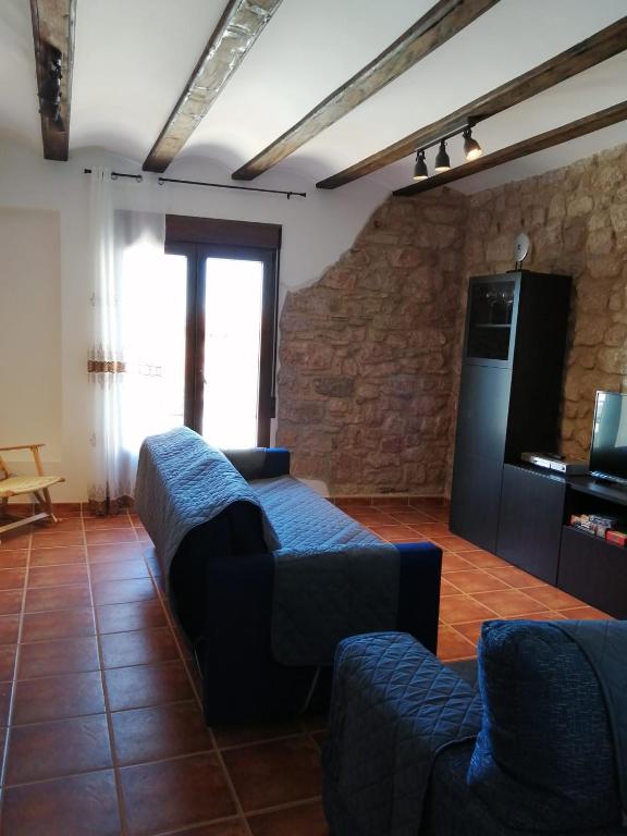 a living room with a couch and a tv at Casa Las Torres in Mora de Rubielos