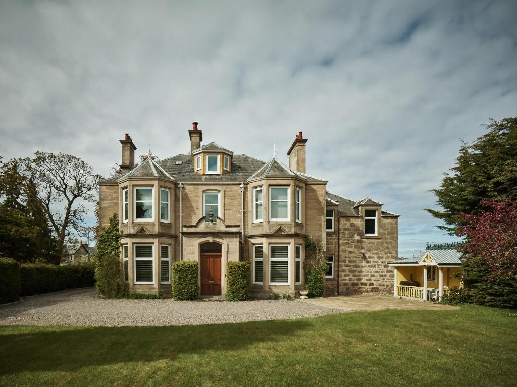 a large brick house with a red door at Tali Ayer in Nairn