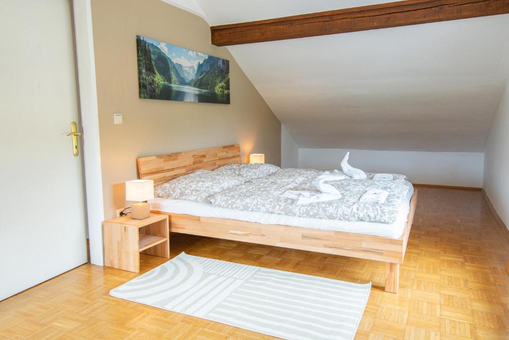 Schlafzimmer mit einem großen Bett mit einem Kopfteil aus Holz in der Unterkunft Lions Apartments - Erholung und Vergnügen in Bad Tatzmannsdorf in Jormannsdorf