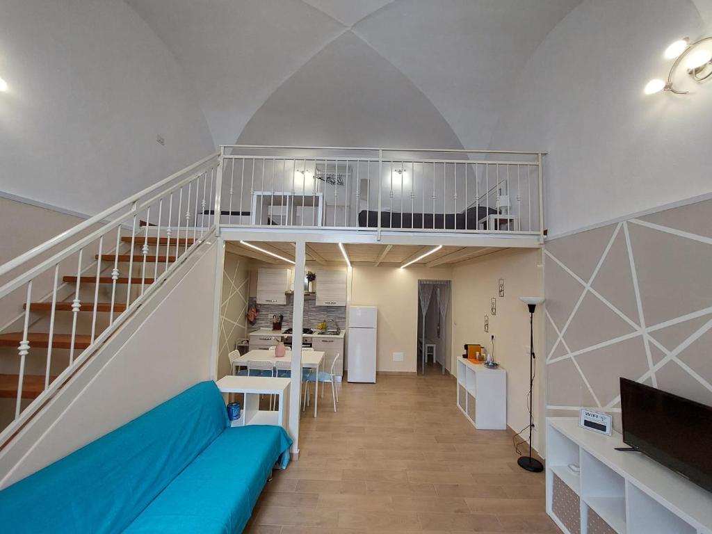 ein Wohnzimmer mit einem blauen Sofa und einer Treppe in der Unterkunft Casa vacanze Mezzanine in Catania