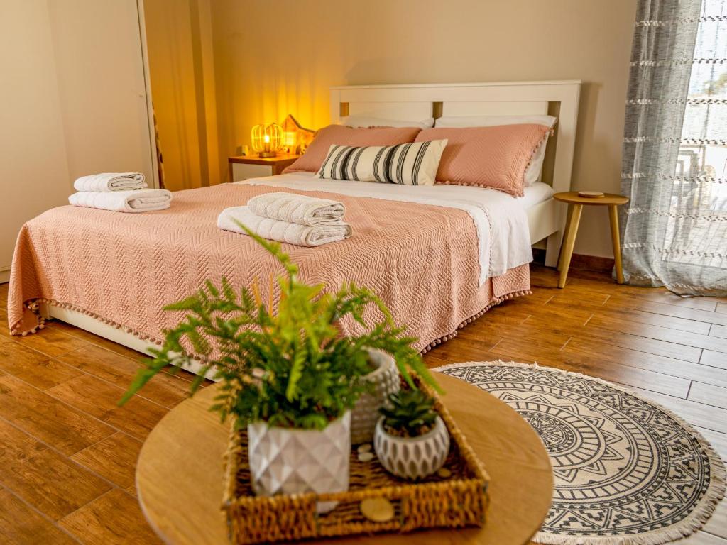 a bedroom with a bed and a table with plants at Frida appartment in Preveza