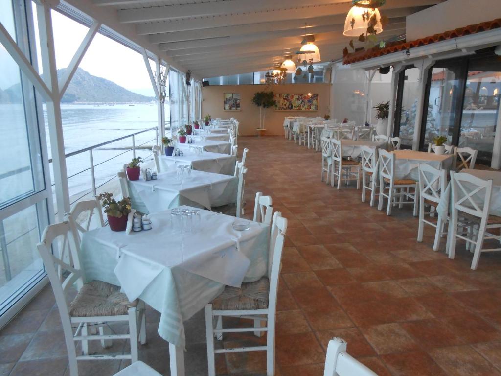 a row of tables and chairs in a restaurant at Hotel Assini Beach Tolo in Tolo