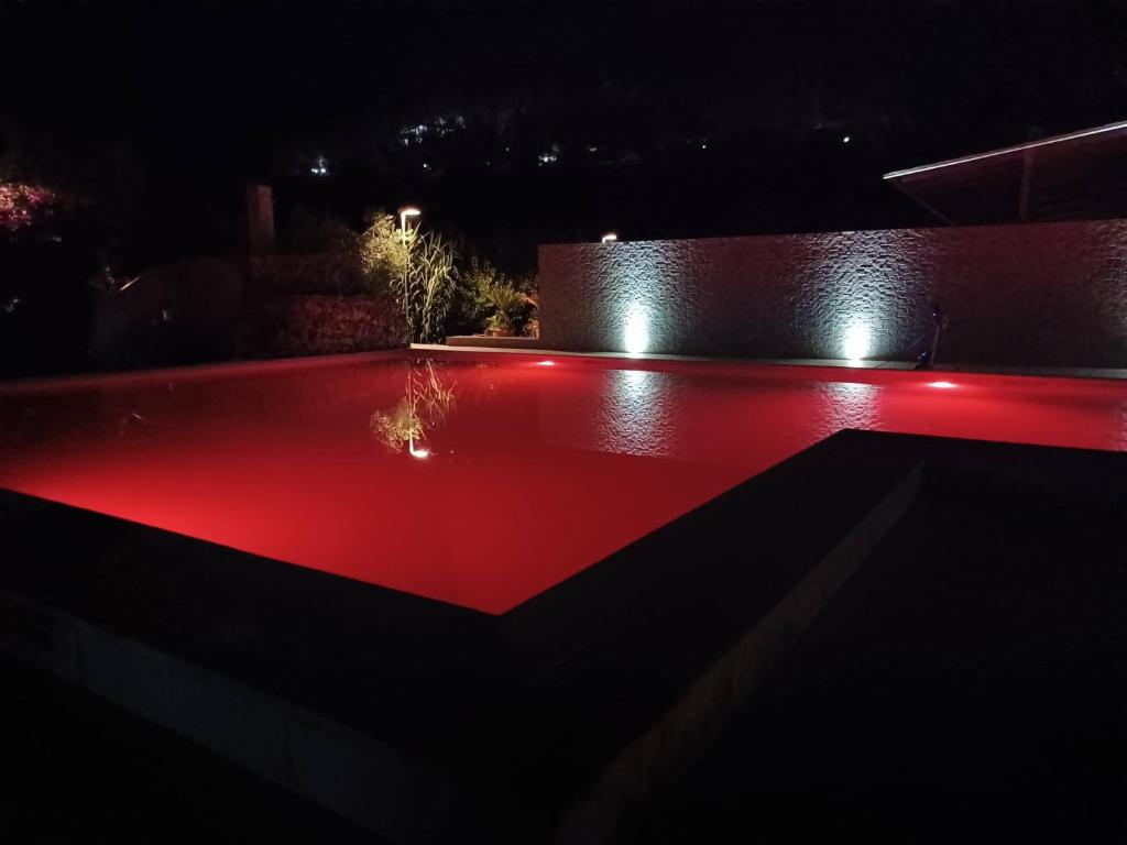 uma piscina com iluminação vermelha à noite em Hotel Parco Carabella partner Elite Hotels em Vieste