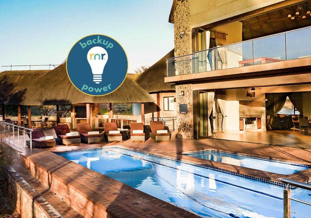 a hotel with a swimming pool in front of a building at Zebula 8 Bedroom Lodge – IV1 in Mabula