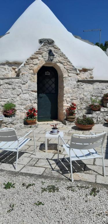 a stone building with two chairs and a table at Trullo Donna Caterina in Ceglie Messapica