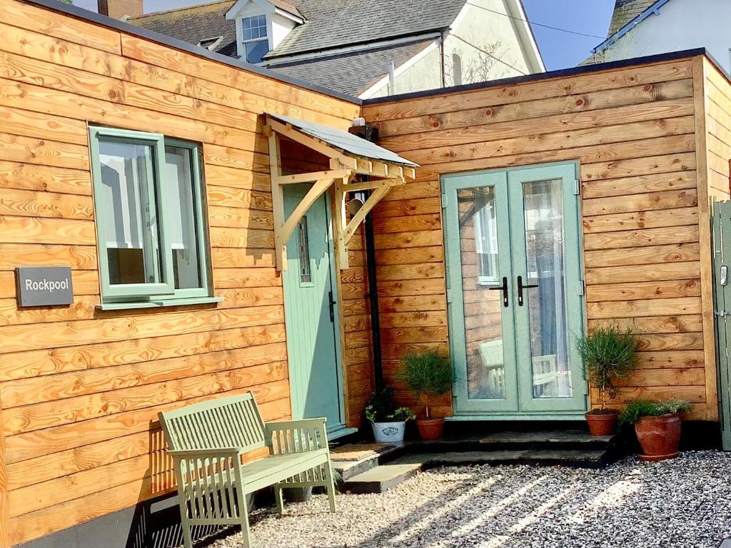 a wooden house with two benches in front of it at Rockpool - Bude in Bude