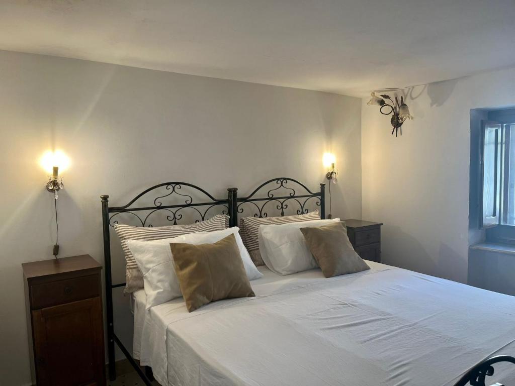 una camera da letto con letto, lenzuola e cuscini bianchi di Housalento a Francavilla Fontana