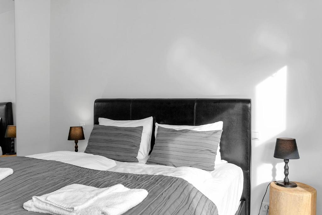 a bedroom with a large bed with white sheets and pillows at Baron Downtown Apartments in Reykjavík
