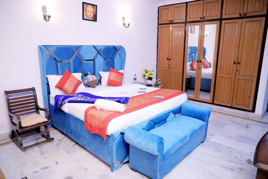 una camera con un letto blu e una sedia di Divine India Service Apartment,2Bhk, D-198,SAKET a Nuova Delhi