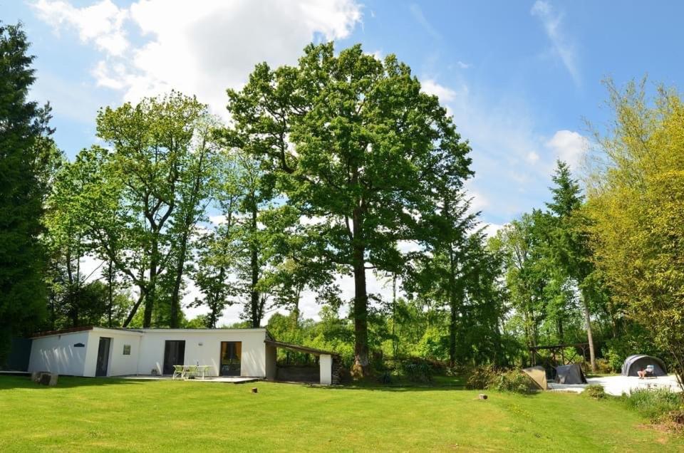 un piccolo capanno bianco in un campo con alberi di Lac Cimes a Pagéas