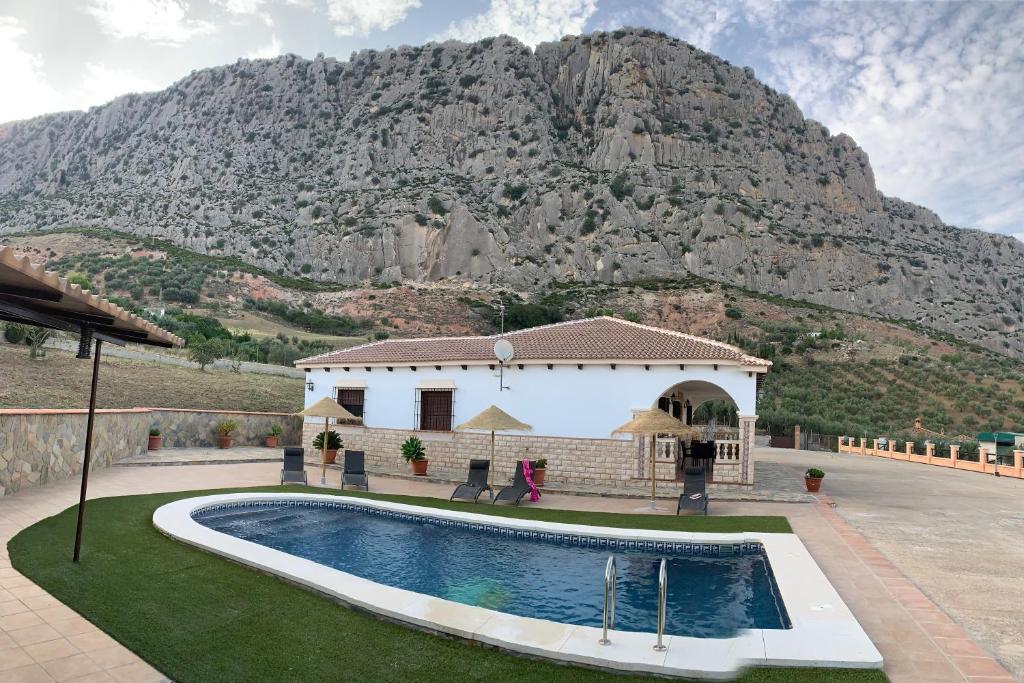 a house with a swimming pool in front of a mountain at Casa de María in Valle de Abdalagís