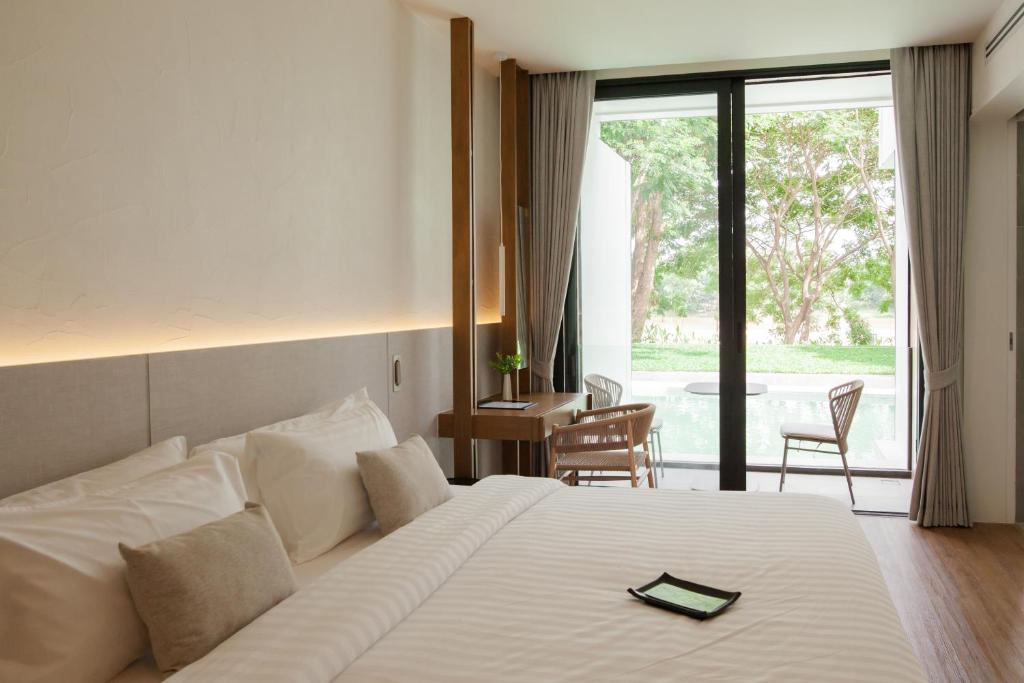 Postel nebo postele na pokoji v ubytování Riva Vista Riverfront Resort Chiang Rai