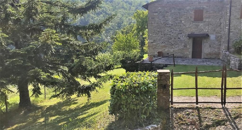 a building with a gate in front of a yard at Casa Titina Riposo e Relax nella campagna toscana in Pratovecchio