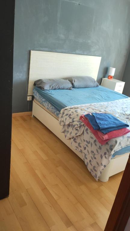 a bedroom with a bed with blue sheets and a wooden floor at Bloque de Viviendas in Ibiza Town