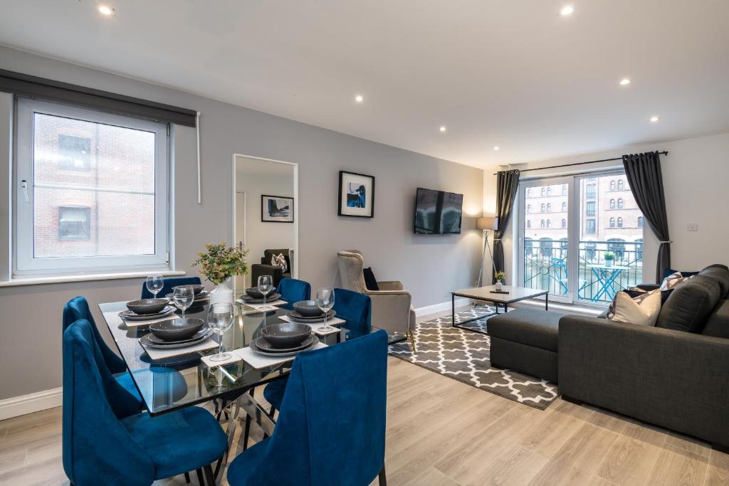een woonkamer met een tafel en blauwe stoelen bij Fabulous Quayside Apartment with Free Parking in Liverpool