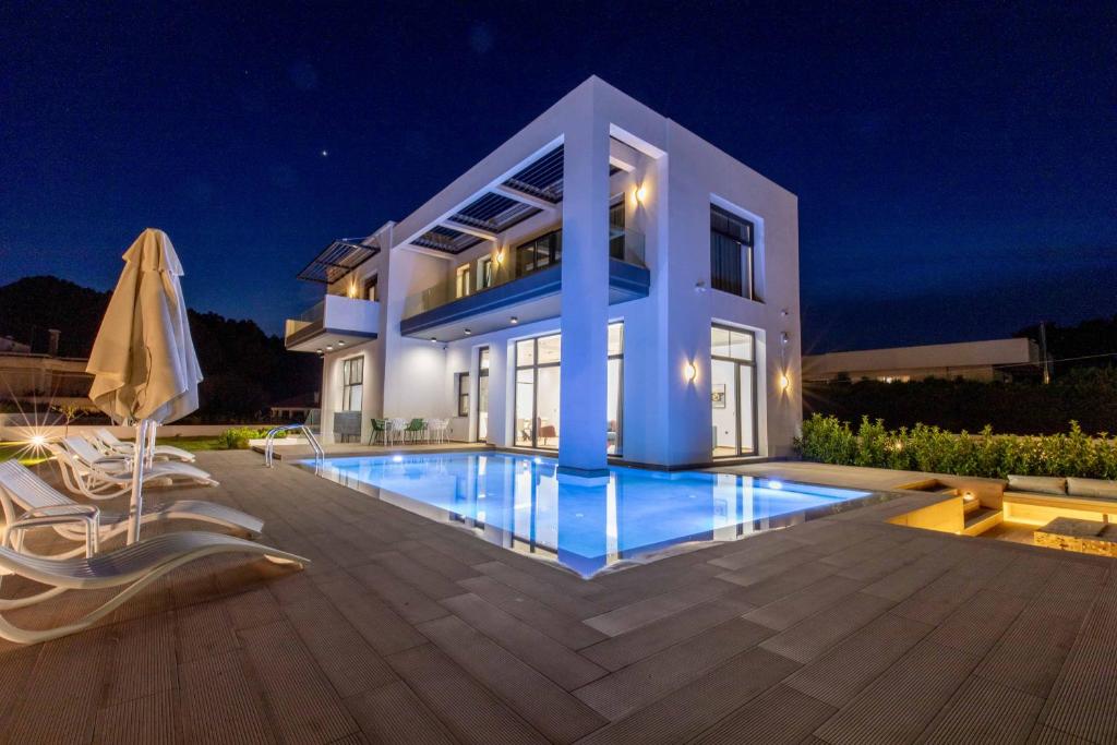 a villa with a swimming pool at night at Armonia Luxury Villa in Ialysos